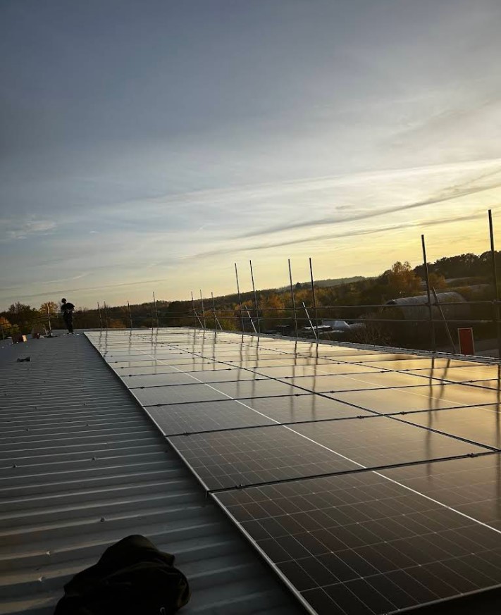 Solar panels on rooftop at sunset.
