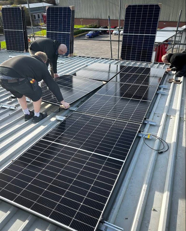 Workers installing solar panels on rooftop