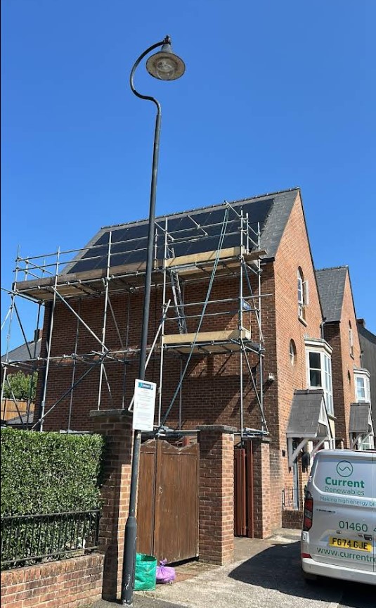 House with solar panels and scaffolding installed.