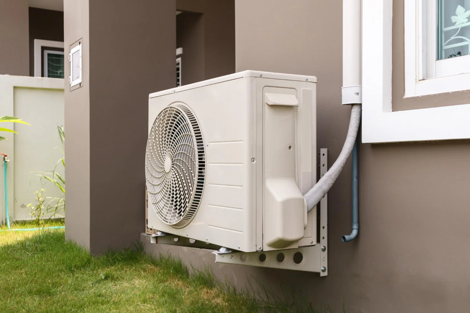 Outdoor air conditioning unit mounted beside a house